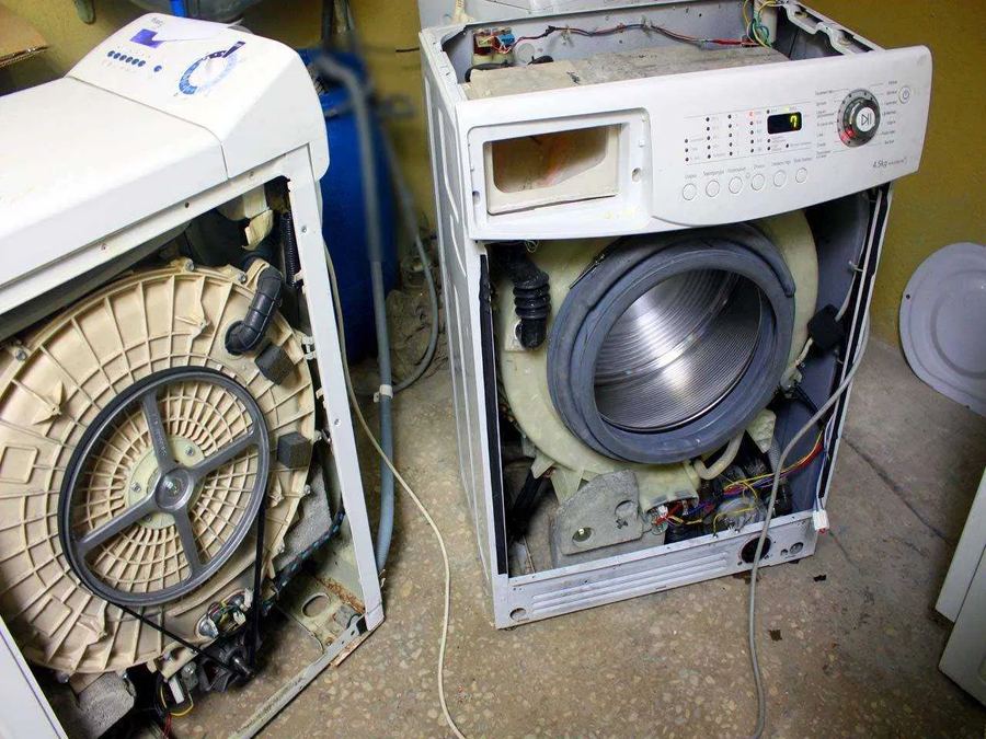 Разобранный бак стиральной машины со шкивом и приводным ремнём